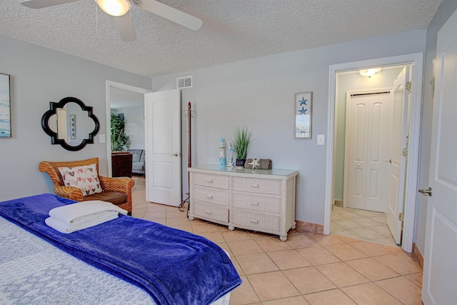 tiled bedroom featuring a textured ceiling and ceiling fan