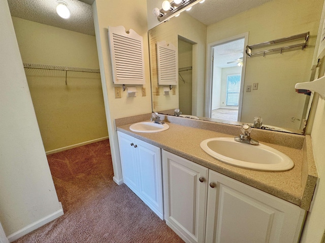 221 Mayan Ter, Saint Augustine, FL 32080 - bathroom featuring double vanity, a textured ceiling, a walk in closet, and ceiling fan