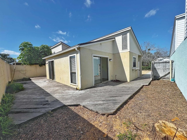 221 Mayan Ter, Saint Augustine, FL 32080 - back of property with stucco siding, a fenced backyard, and a deck