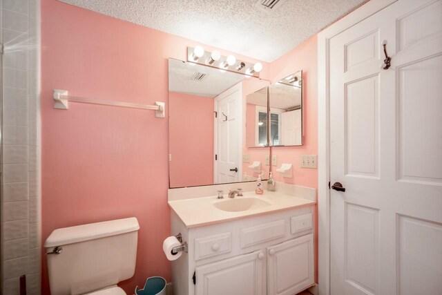 6170 A1A S Unit 101, Saint Augustine, FL 32080 - full bathroom featuring toilet, vanity, a textured ceiling, and a shower