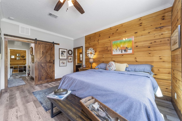 10635 Beckenger Ave, Hastings, FL 32145 - bedroom featuring visible vents, a barn door, wood finished floors, and a textured ceiling