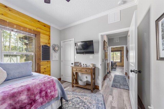 10635 Beckenger Ave, Hastings, FL 32145 - bedroom with crown molding, wood finished floors, a textured ceiling, baseboards, and visible vents