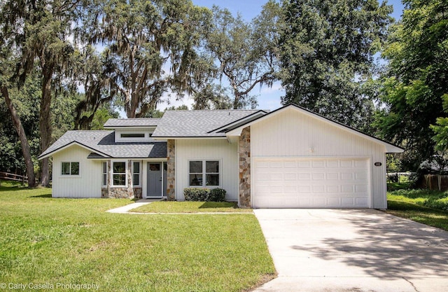 552 Fox Hollow Ln, Saint Augustine, FL 32086 - view of front facade with stone siding, concrete driveway, a shingled roof, an attached garage, and a front yard