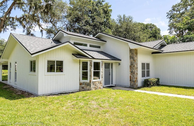 552 Fox Hollow Ln, Saint Augustine, FL 32086 - view of front of property featuring a shingled roof, a front yard, and stone siding