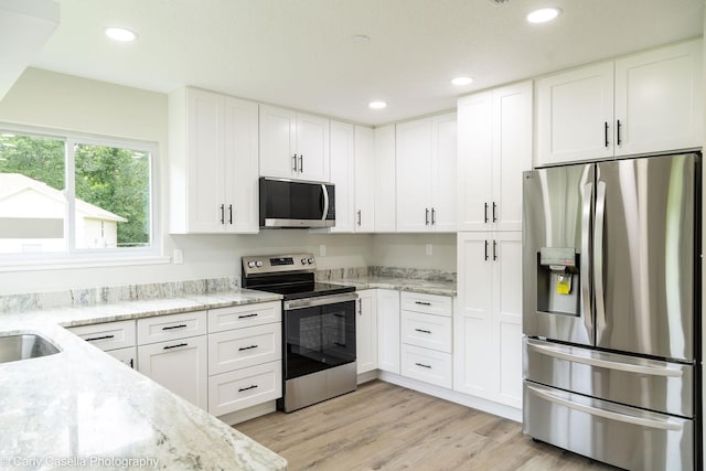 552 Fox Hollow Ln, Saint Augustine, FL 32086 - kitchen featuring stainless steel appliances, white cabinets, light stone countertops, light wood-type flooring, and recessed lighting