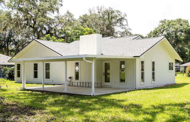 552 Fox Hollow Ln, Saint Augustine, FL 32086 - rear view of property featuring roof with shingles, a chimney, a yard, and a patio