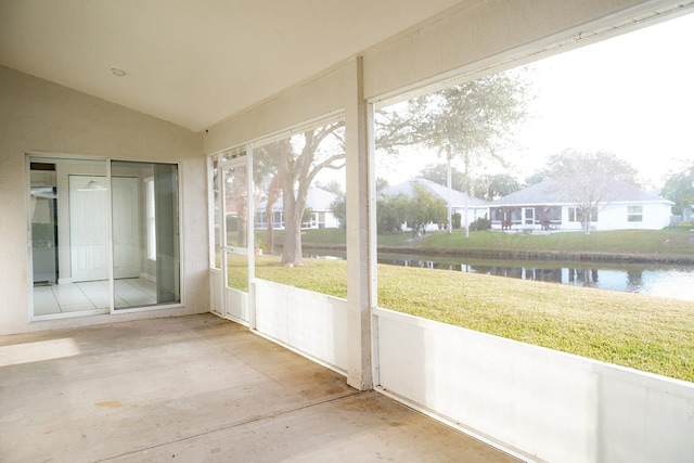 unfurnished sunroom featuring a water view and lofted ceiling