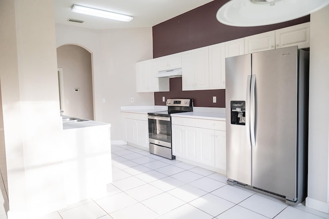 kitchen featuring appliances with stainless steel finishes, sink, light tile patterned floors, and white cabinets