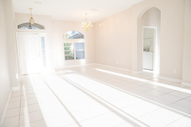 unfurnished room featuring light tile patterned floors and a chandelier