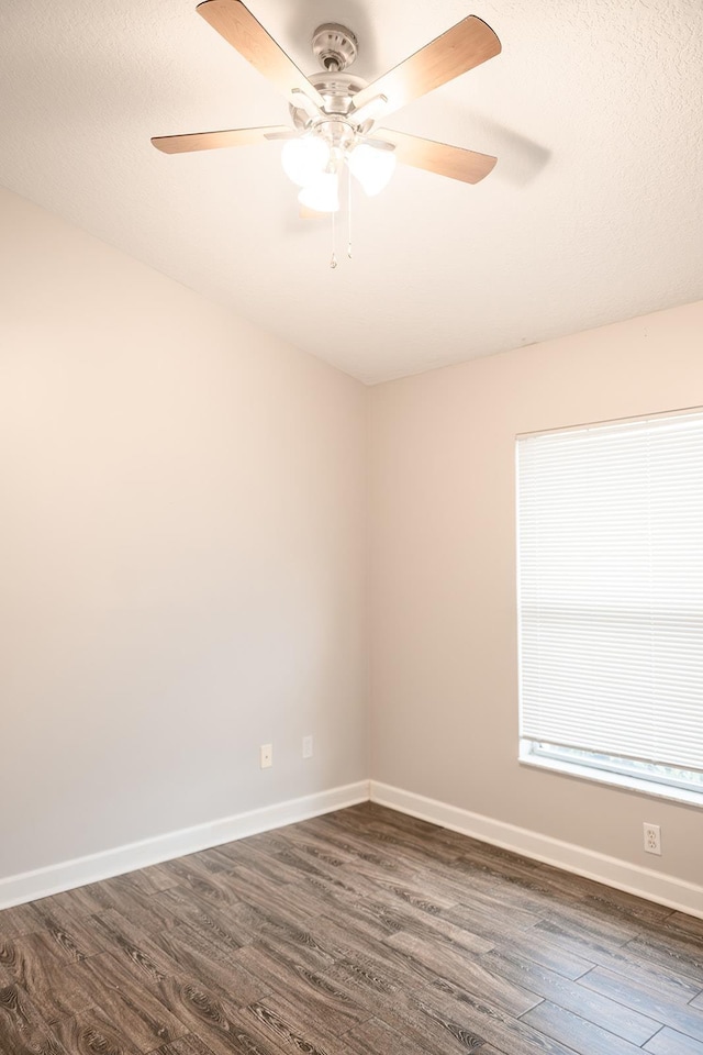 spare room with dark hardwood / wood-style floors and ceiling fan