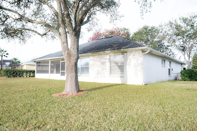 back of property with a sunroom and a yard