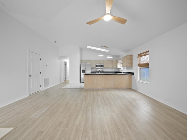 unfurnished living room with vaulted ceiling, sink, ceiling fan, and light hardwood / wood-style floors