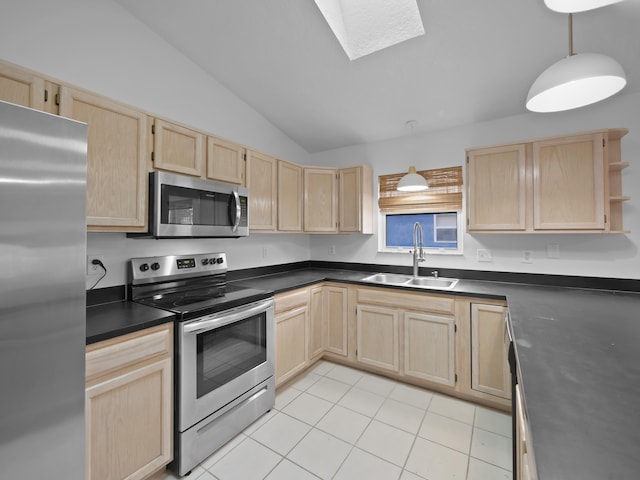 kitchen with light brown cabinetry, sink, hanging light fixtures, stainless steel appliances, and vaulted ceiling with skylight