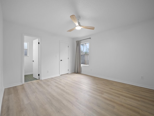 unfurnished bedroom with light hardwood / wood-style flooring, ceiling fan, and ensuite bathroom