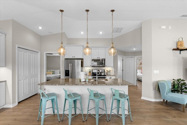 403 Second St, Saint Augustine, FL 32084 - kitchen featuring a breakfast bar area, baseboards, an island with sink, and appliances with stainless steel finishes