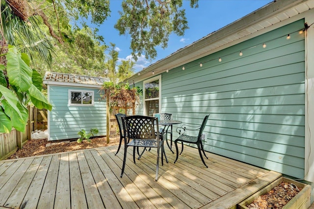 403 Second St, Saint Augustine, FL 32084 - wooden deck featuring a storage shed, outdoor dining space, a fenced backyard, and an outdoor structure