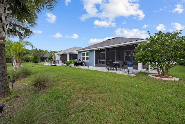 back of property featuring a patio, a lawn, and a sunroom