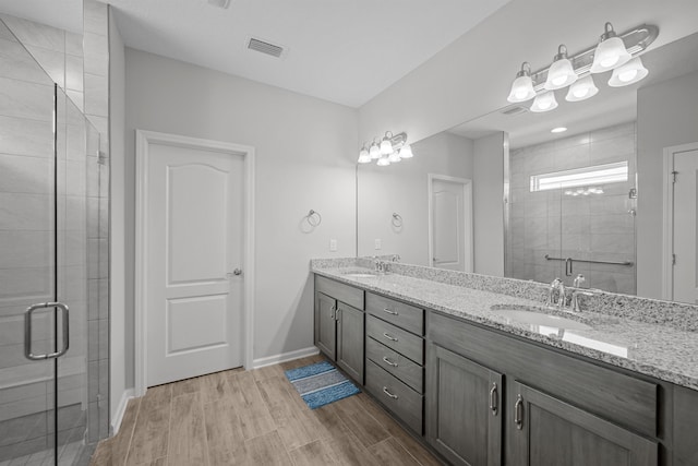 bathroom with vanity, wood-type flooring, and a shower with door