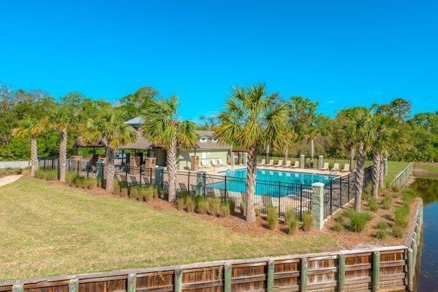 view of swimming pool with a lawn and a water view