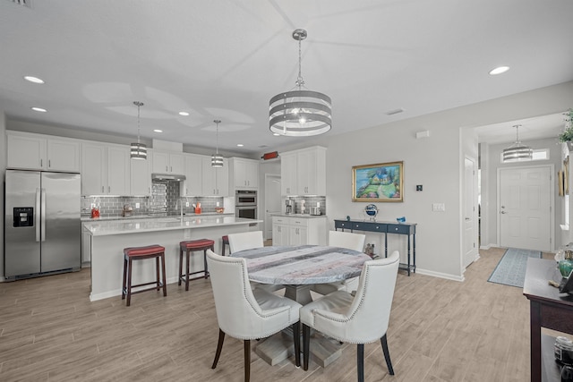 dining space with light wood-type flooring and a chandelier