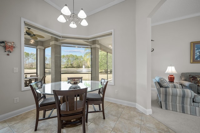 tiled dining space featuring a healthy amount of sunlight, ornamental molding, and ceiling fan with notable chandelier