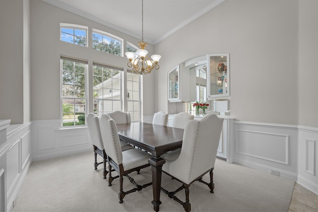 carpeted dining area featuring an inviting chandelier and ornamental molding