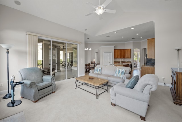 carpeted living room featuring ceiling fan, ornamental molding, sink, and high vaulted ceiling