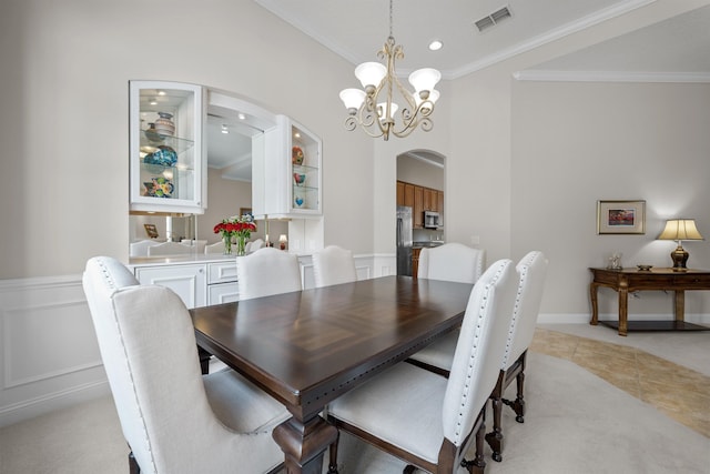 dining area with crown molding, light tile patterned flooring, and a notable chandelier