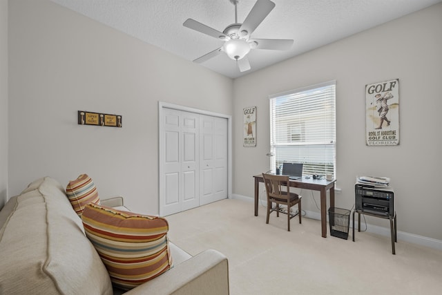 carpeted office space featuring ceiling fan and a textured ceiling