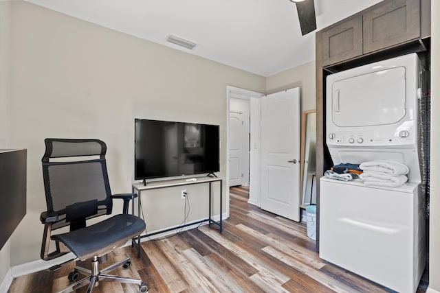 interior space featuring hardwood / wood-style floors and stacked washing maching and dryer