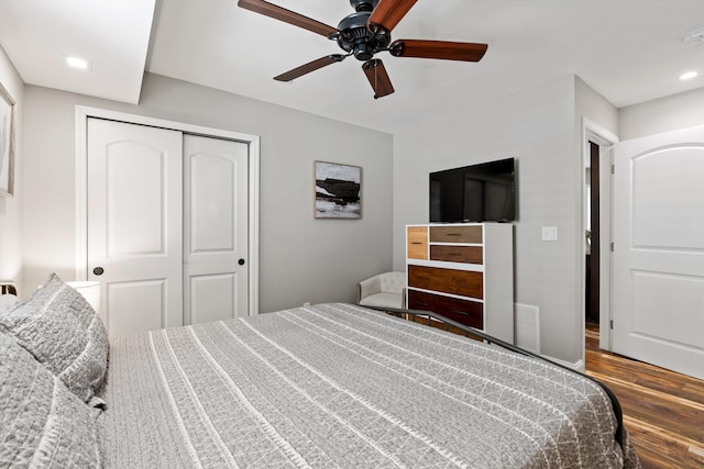 bedroom featuring ceiling fan, dark hardwood / wood-style floors, and a closet