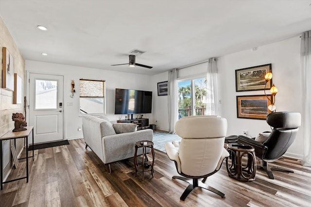 living room with ceiling fan and dark wood-type flooring