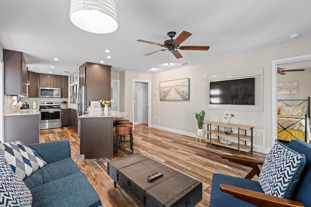 living room with ceiling fan and light hardwood / wood-style floors