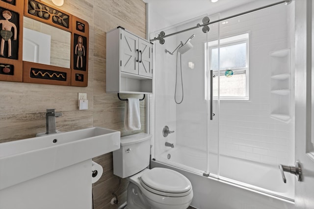 bathroom with combined bath / shower with glass door, toilet, decorative backsplash, and tile walls