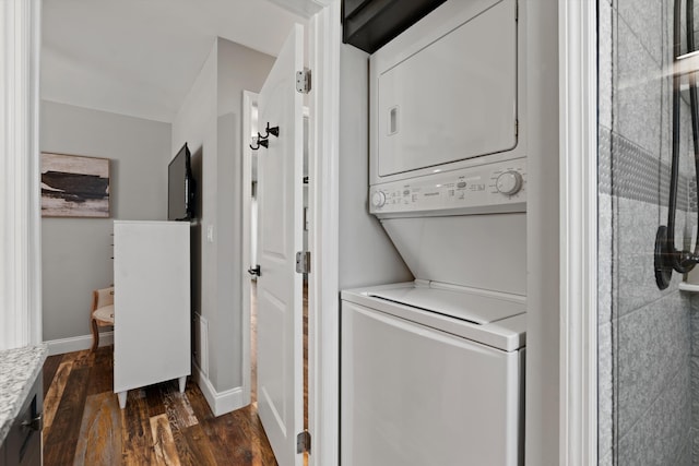 laundry area with dark hardwood / wood-style floors and stacked washer and clothes dryer