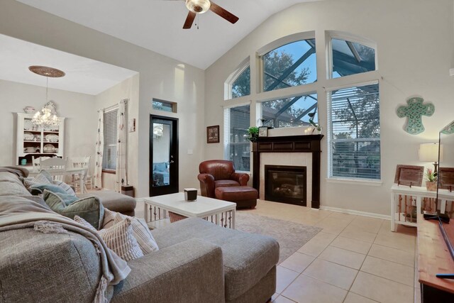 living room featuring ceiling fan with notable chandelier, high vaulted ceiling, and light tile patterned floors