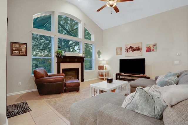 living room featuring ceiling fan, a fireplace, high vaulted ceiling, and light tile patterned floors