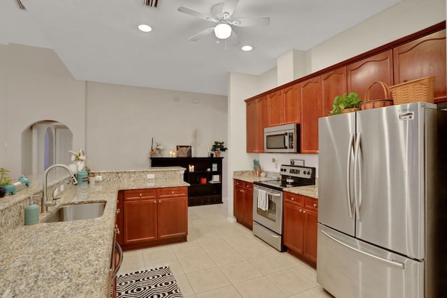 kitchen featuring sink, light stone counters, kitchen peninsula, ceiling fan, and stainless steel appliances