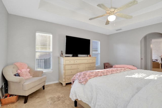 bedroom with a tray ceiling and ceiling fan