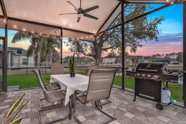 sunroom featuring ceiling fan, a healthy amount of sunlight, and vaulted ceiling