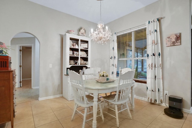 dining area with light tile patterned floors and an inviting chandelier