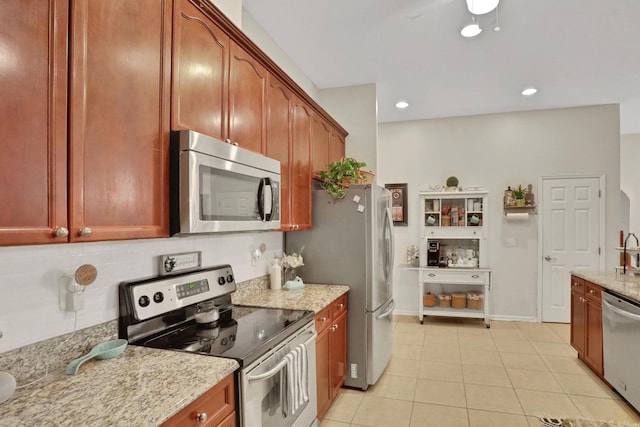 kitchen featuring stainless steel appliances, light stone countertops, light tile patterned floors, and decorative backsplash