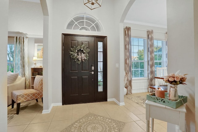 entrance foyer featuring ornamental molding and light tile patterned floors