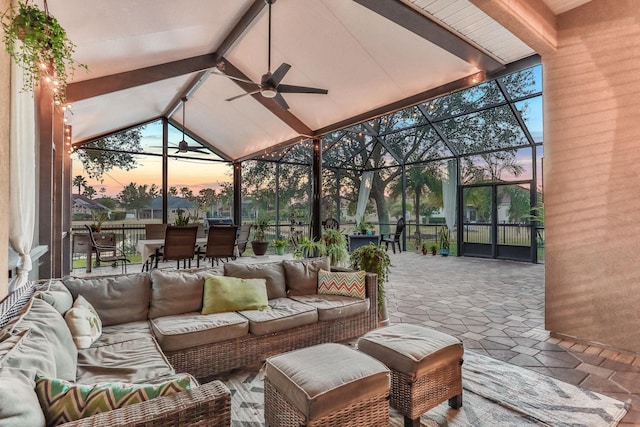 patio terrace at dusk with outdoor lounge area, ceiling fan, and a lanai