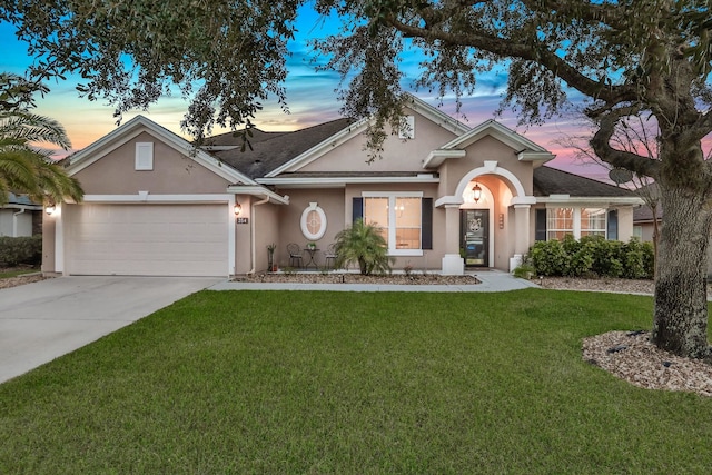 ranch-style home with a garage and a lawn