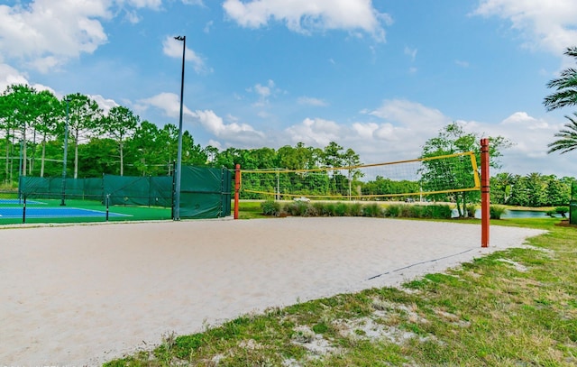 view of home's community with a water view and volleyball court