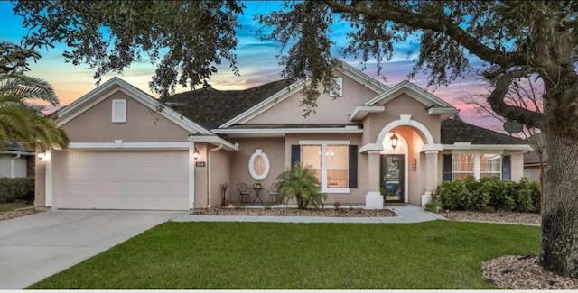 single story home with a garage and a yard