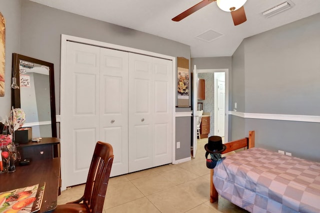 tiled bedroom with connected bathroom, ceiling fan, and a closet