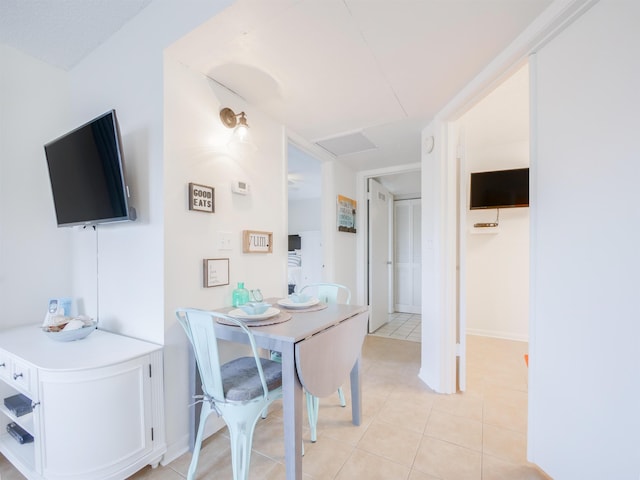 dining space with attic access and light tile patterned flooring