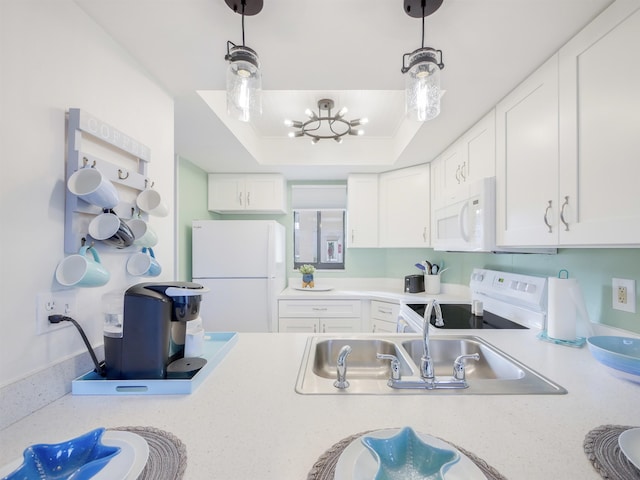 kitchen featuring white cabinets, white appliances, light countertops, and a tray ceiling